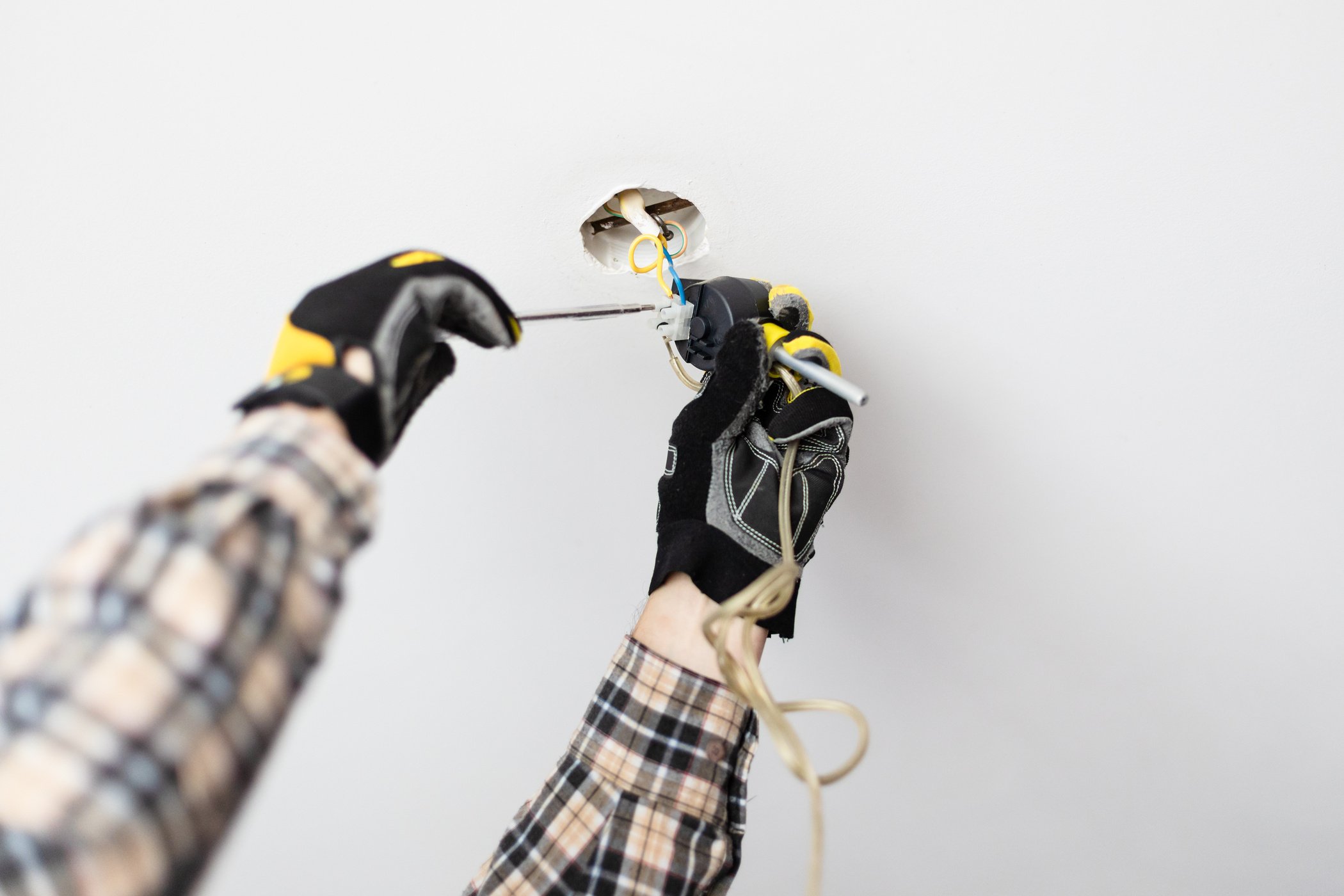 Electrician Repairing Electrical Wiring of Lamp